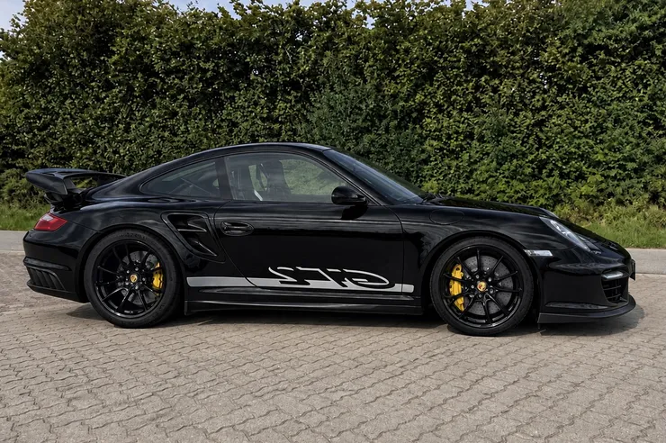 Zuletzt angekaufter Porsche 911 GT2 in Schwarz vor einer Hecke